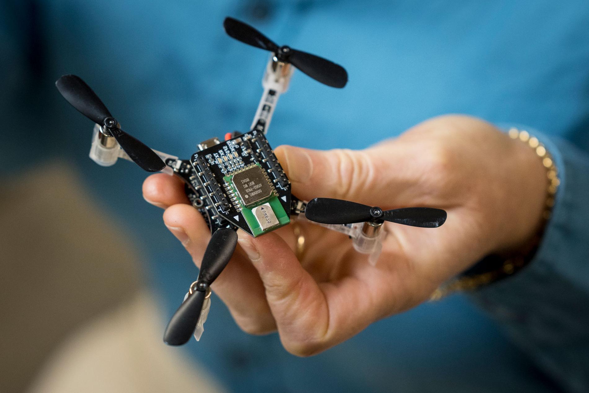 A person holding a small drone with propellers